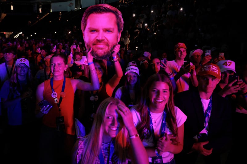 Attendees hold up a large image of U.S. Vice President JD Vance's face as he takes the stage during a Turning Point USA event in the Akins Ford Arena on the campus of the University of Georgia in Athens, Georgia, U.S. April 14, 2026.