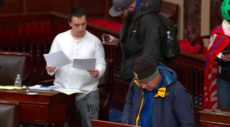 Christopher Moynihan rifling through papers in the Senate Chamber on Jan 6.