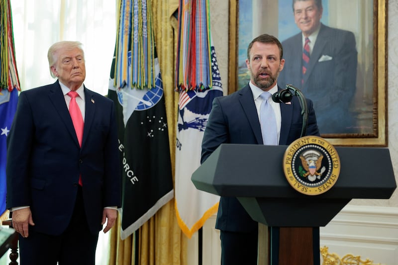 U.S. President Donald Trump flanks Markwayne Mullin as he speaks after being sworn in as Department of Homeland Security (DHS) Secretary at the White House in Washington, D.C., U.S., March 24, 2026.