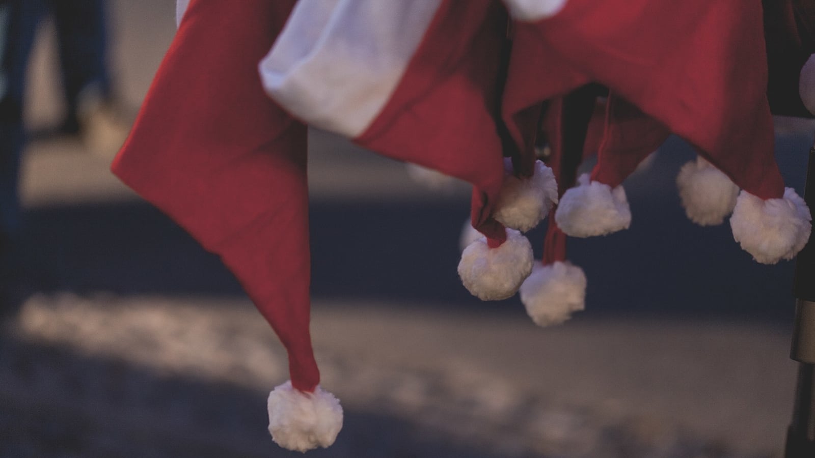 Santa hats hang from a rack.