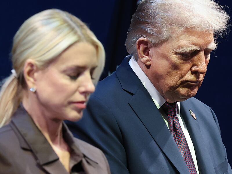 President Donald Trump bows his head in prayer with Attorney General Pam Bondi  at the Museum of the Bible.