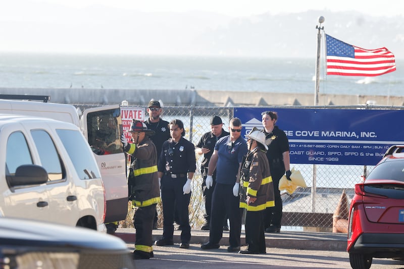 Emergency responders shelter a deceased victim.