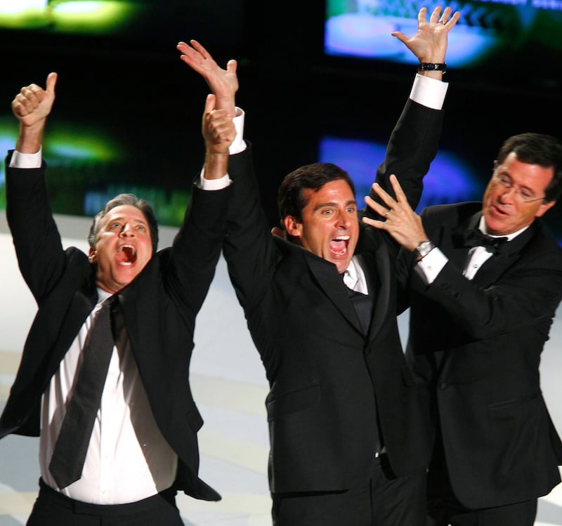 Jon Stewart (L) and Stephen Colbert (R) celebrate with actor Steve Carell in 2007