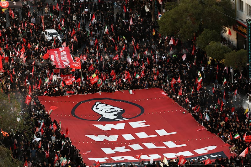 Iranian mourners carry a banner threatening Trump on the day of the burial of former Supreme Leader Ayatollah Ali Khamenei, who was killed on February 28 in Israeli and U.S. airstrikes.