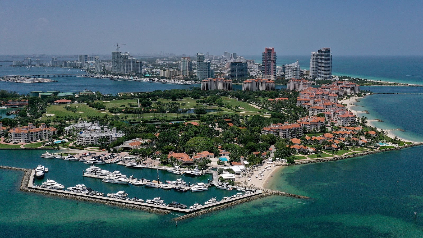 MIAMI, FLORIDA - JULY 11: In an aerial view, Fisher Island (foreground) along with Miami Beach sit next to the Atlantic Ocean on July 11, 2023 in Miami, Florida. The surface ocean temperatures in parts of Florida are 92 to 96 degrees Fahrenheit, the warmer coastal ocean water is threatening Florida's coral reefs, and could create stronger tropical storms and hurricanes. (Photo by Joe Raedle/Getty Images)