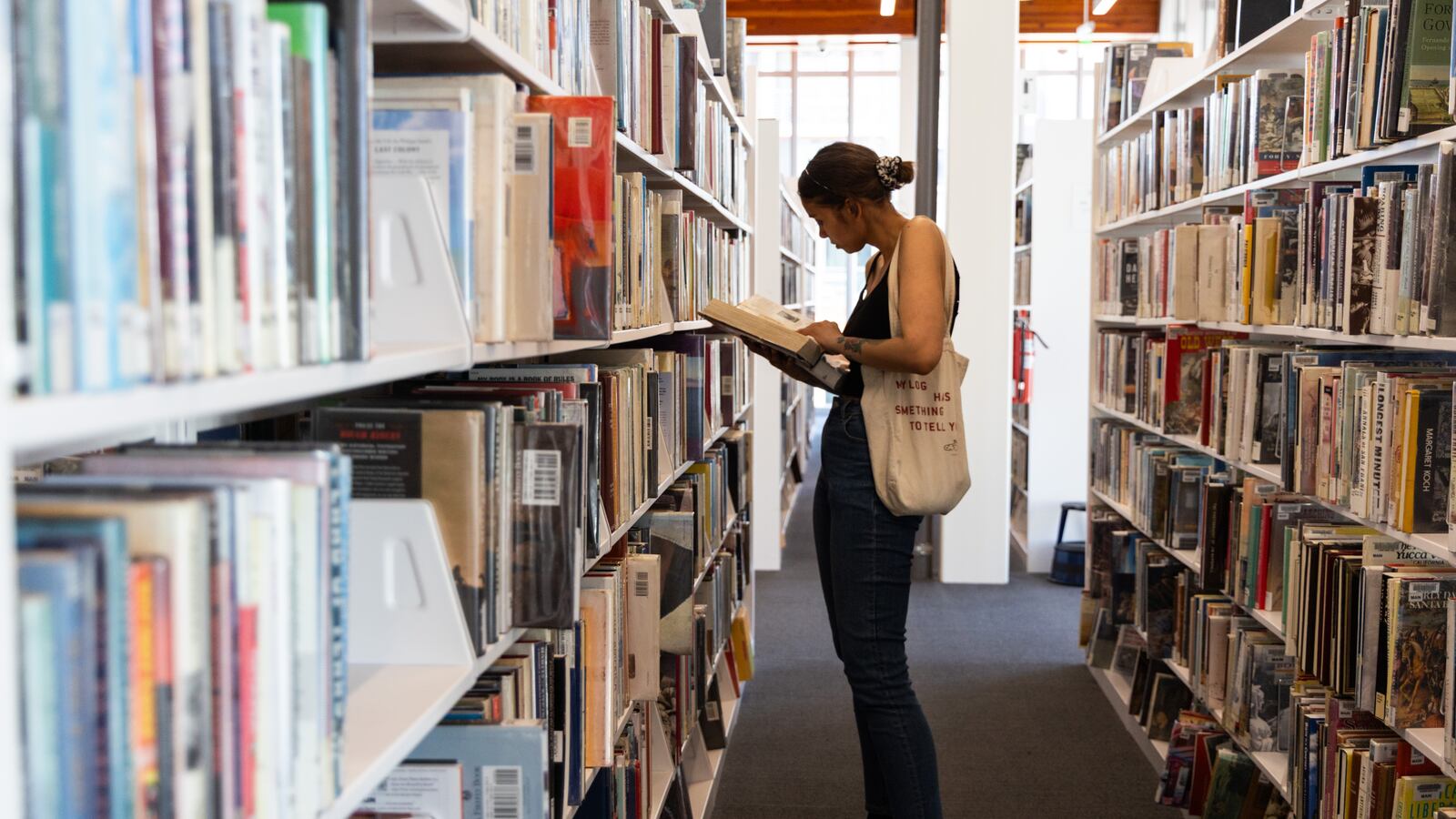 Long Beach, CA - August 07: Rebecca Leis browses through books at Billie Jean King Main Library on Thursday, Aug. 7, 2025 in Long Beach, CA.
