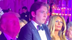 Barron Trump stands between his president after, Donald, and FLOTUS's mother, Melania, at the New Year's party at Mar-a-Lago.