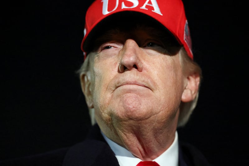 U.S. President Donald Trump looks on after disembarking Air Force One