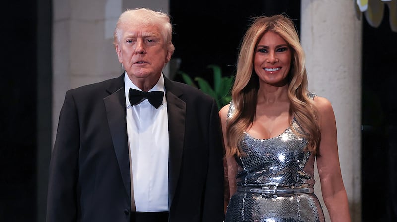 PALM BEACH, FLORIDA - DECEMBER 31: U.S. President Donald Trump and first lady Melania Trump arrive for a New Year’s Eve event at his Mar-a-Lago home on December 31, 2025 in Palm Beach, Florida. The president addressed guests and celebrated the arrival of 2026. (Photo by Joe Raedle/Getty Images)