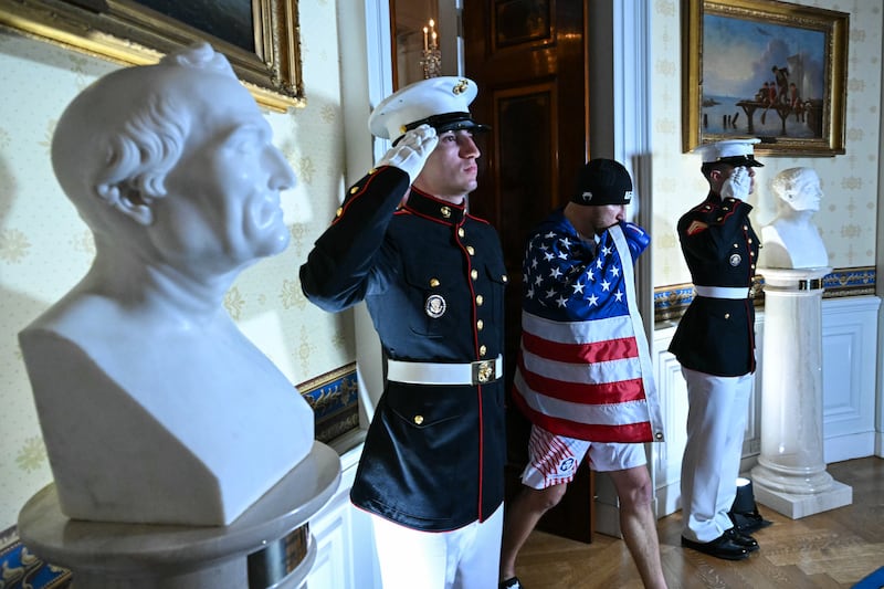 WASHINGTON, DC - JUNE 15: US Marines salute as America's Justin Gaethje walks into the Blue Room of the White House before the start of his lightweight title bout against Georgia's Ilia Topuria during the "UFC Freedom 250" mixed martial arts event on June 15, 2026 in Washington, DC. President Donald Trump is hosting a series of Ultimate Fighting Championship matches on his 80th birthday, which the White House is calling "a once-in-a-generation celebration of the American fighting spirit.”