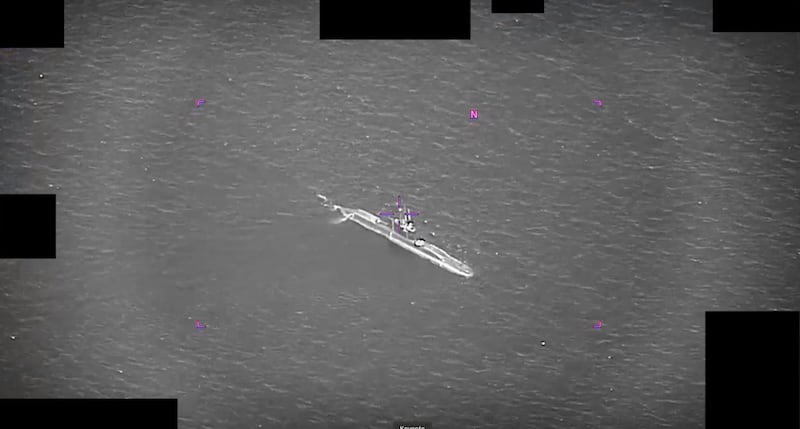Several UAPs whizz around a submarine in the middle of open water.