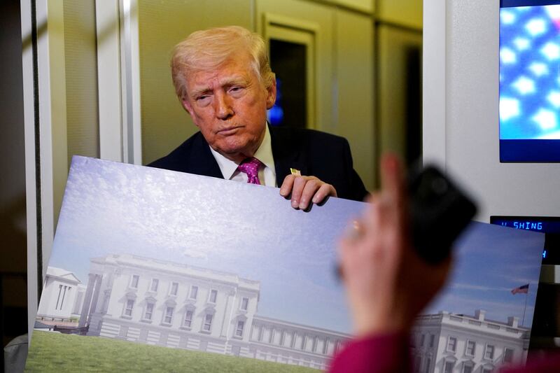 A member of the media raises her hand for a question as U.S. President Donald Trump talks while holding up renderings of the planned White House ballroom, aboard Air Force One en route to Joint Base Andrews, Maryland, U.S., March 29, 2026.