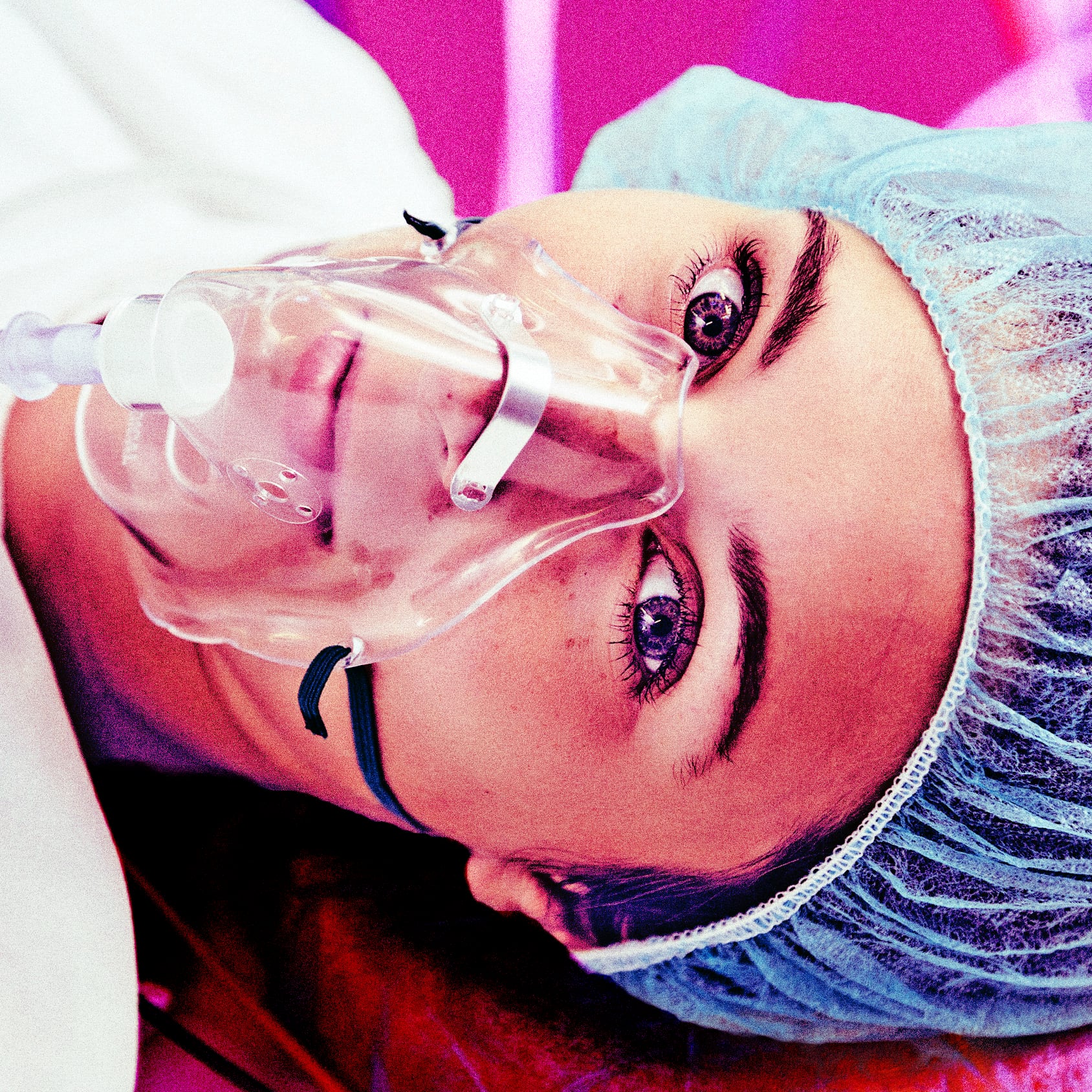 A photo illustration of a patient with respiratory mask awake on operating room table.