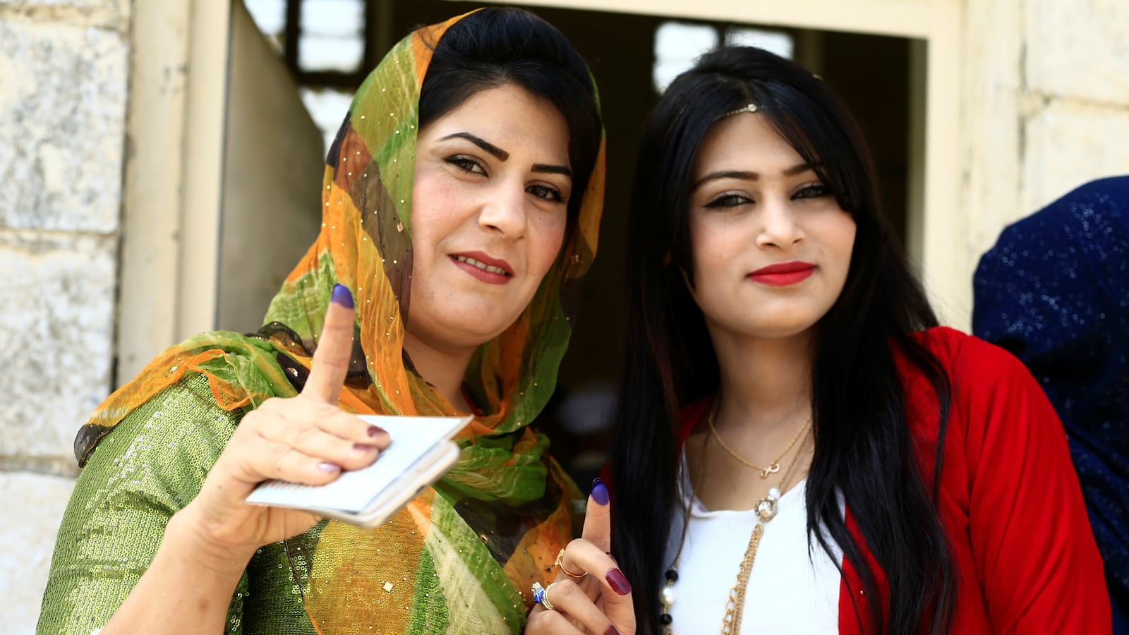 Kurdish women show their ink-stained fingers during Kurds independence referendum in Kirkuk