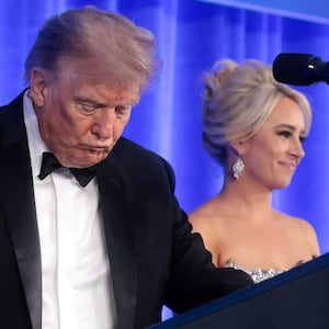 U.S. President Donald Trump, with incoming White House Correspondents' Association (WHCA) President and Fox News Senior White House Correspondent Jacqui Heinrich, takes the lectern to deliver remarks at the WHCA Dinner, which was rescheduled from April after it was interrupted when a man tried to force his way through security and fired a shotgun, at the Waldorf Astoria hotel in Washington, D.C., U.S., July 24, 2026. REUTERS/Jonathan Ernst