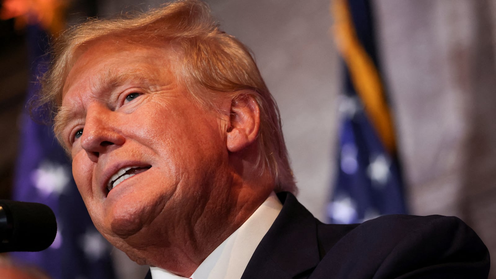 Donald Trump speaking into a microphone.