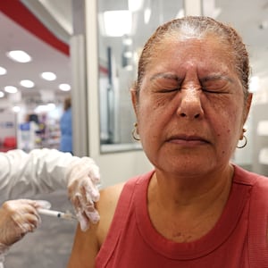 HUNTINGTON PARK-CA-AUGUST 28, 2024: Elizabeth Gomez, 54, of Huntington Park, right, receives a Prevnar and shingles vaccine by pharmacy manager Sandra Gonzalez at CVS in Huntington Park on August 28, 2024. (Christina House / Los Angeles Times via Getty Images)