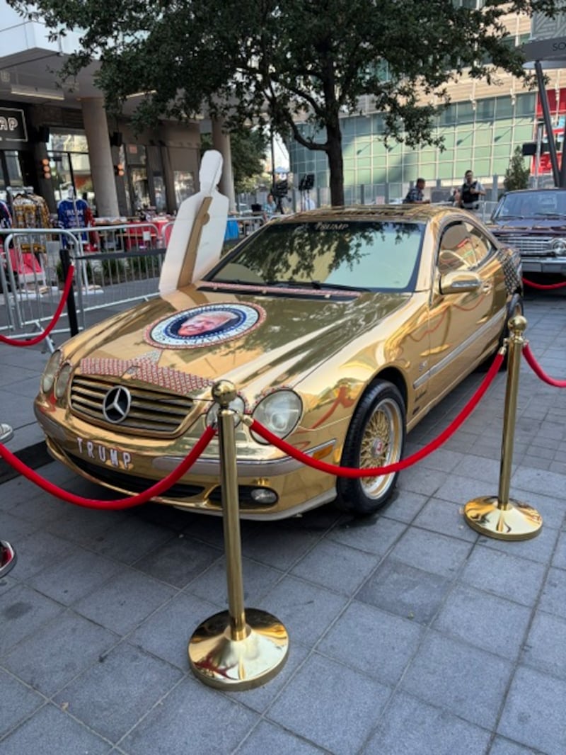 A gold car with a presidential seal featuring Trump's face outside the Republican midterm convention in Dallas.