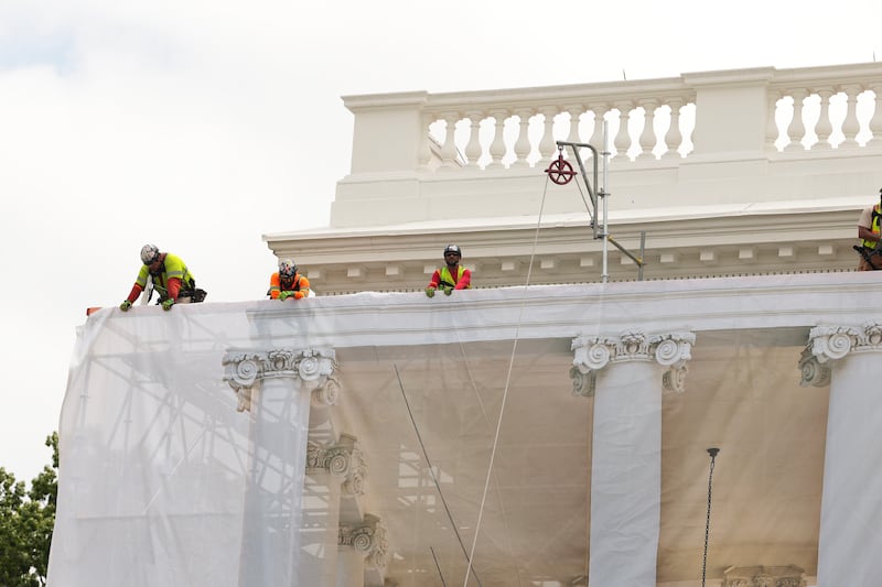 Construction workers place a tarp over the scaffolding that surrounds the columns at the North Portico of the White House on July 09, 2026 in Washington, DC.