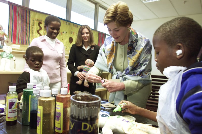 First Lady Laura Bush makes dolls with Children in Botswana in 2003.