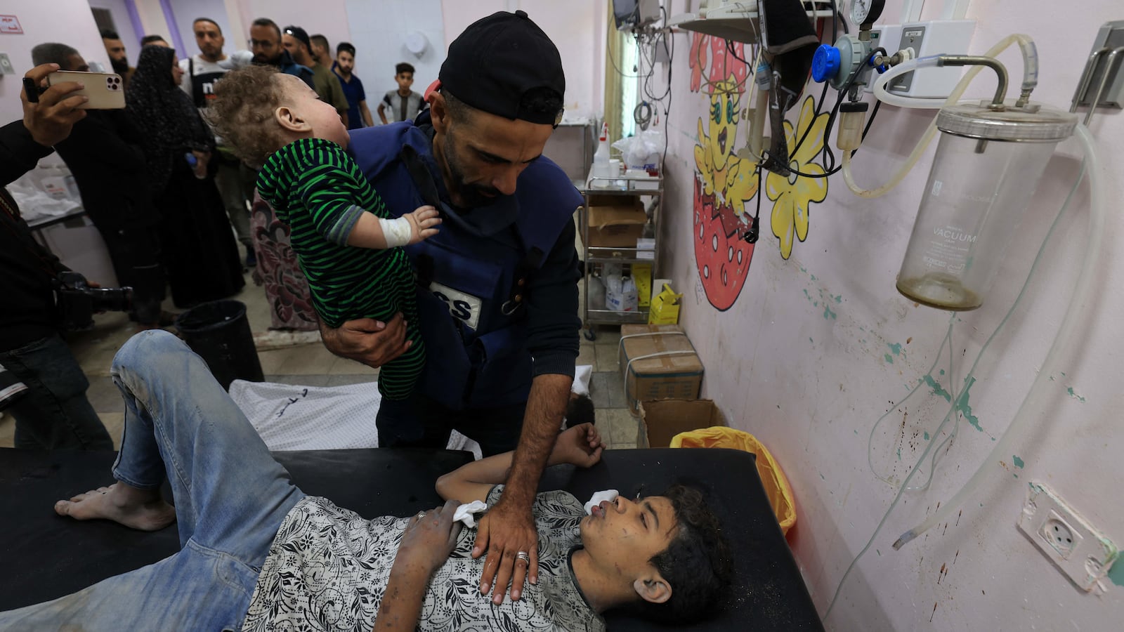 A man holds an injured child at the Al-Quds Hospital in Gaza.