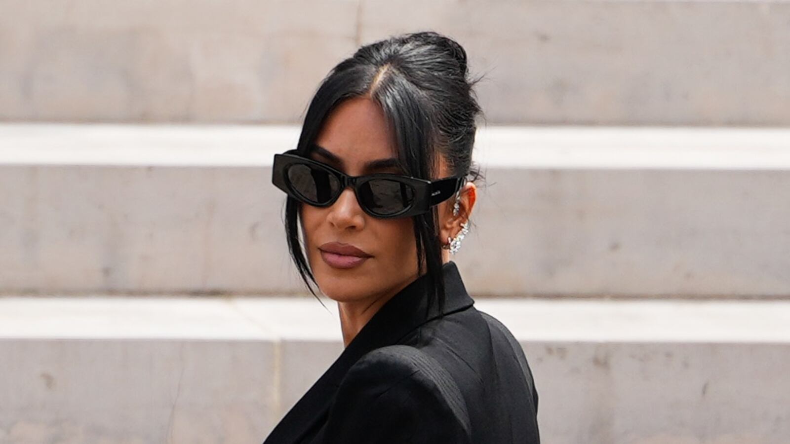 Kim Kardashian arrives at the Palais de Justice, wearing Alaia sunglasses, on May 13, 2025 in Paris, France.