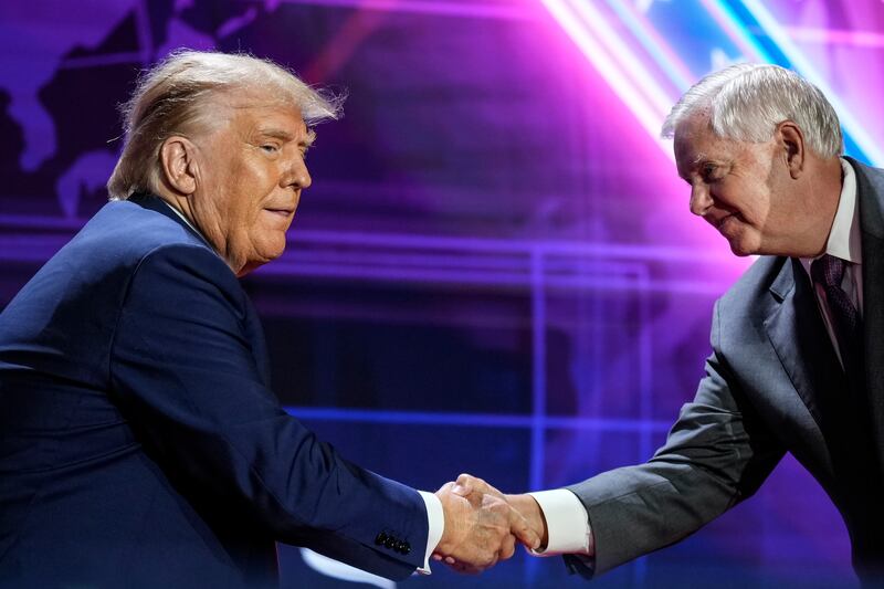 President Donald Trump shakes hands with Sen. Lindsey Graham.