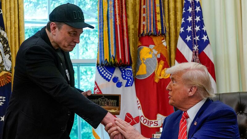 Elon Musk receives a golden key from President Donald Trump in the Oval Office at the White House in Washington, D.C.