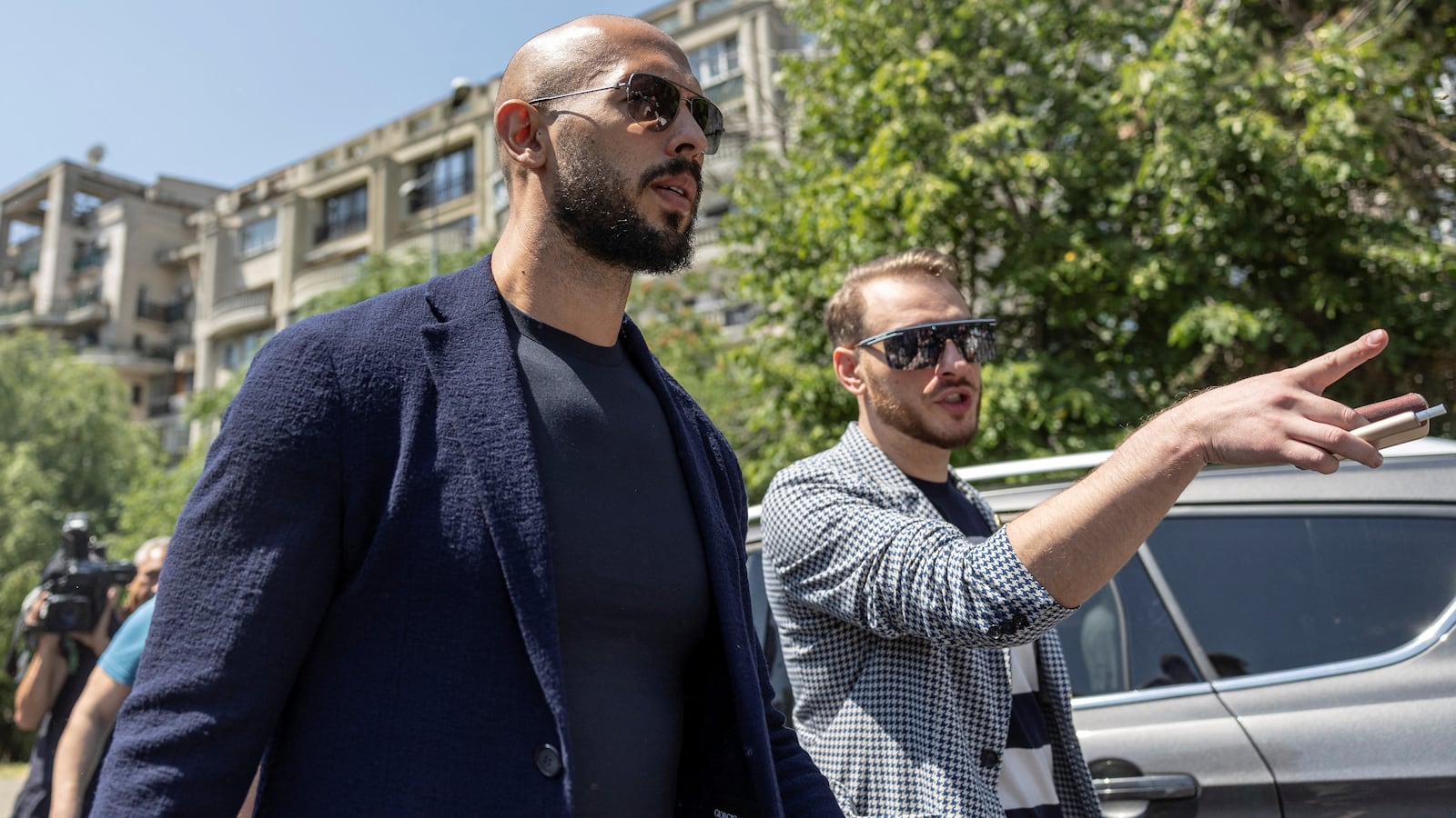 Andrew Tate speaks with his lawyer after he appeared in front of a judge at the Bucharest Courthouse, in Bucharest, Romania, where he will serve even more time under house arrest.