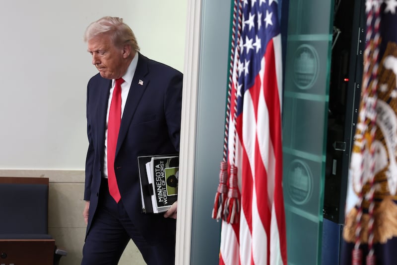 President Donald Trump arrives carrying binders for a press briefing at the White House on January 20, 2026 to mark one year since his return to office.