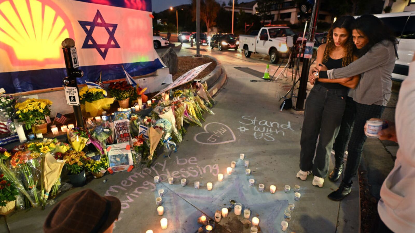 Avia Jacobs, left, and her mother Sharona pay their respects to Paul Kessler , a Jewish supporter.