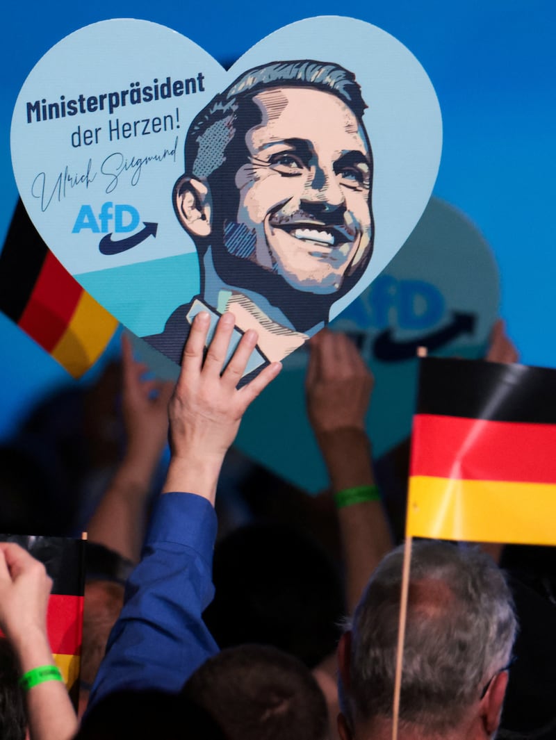A supporter of Ulrich Siegmund, the top candidate of the far-right Alternative for Germany (AfD) party in Germany's Saxony-Anhalt state election, displays a sign at the party's campaign kick-off event ahead of the Saxony-Anhalt state election, in Magdeburg, Germany, July 18, 2026. REUTERS/Christian Mang