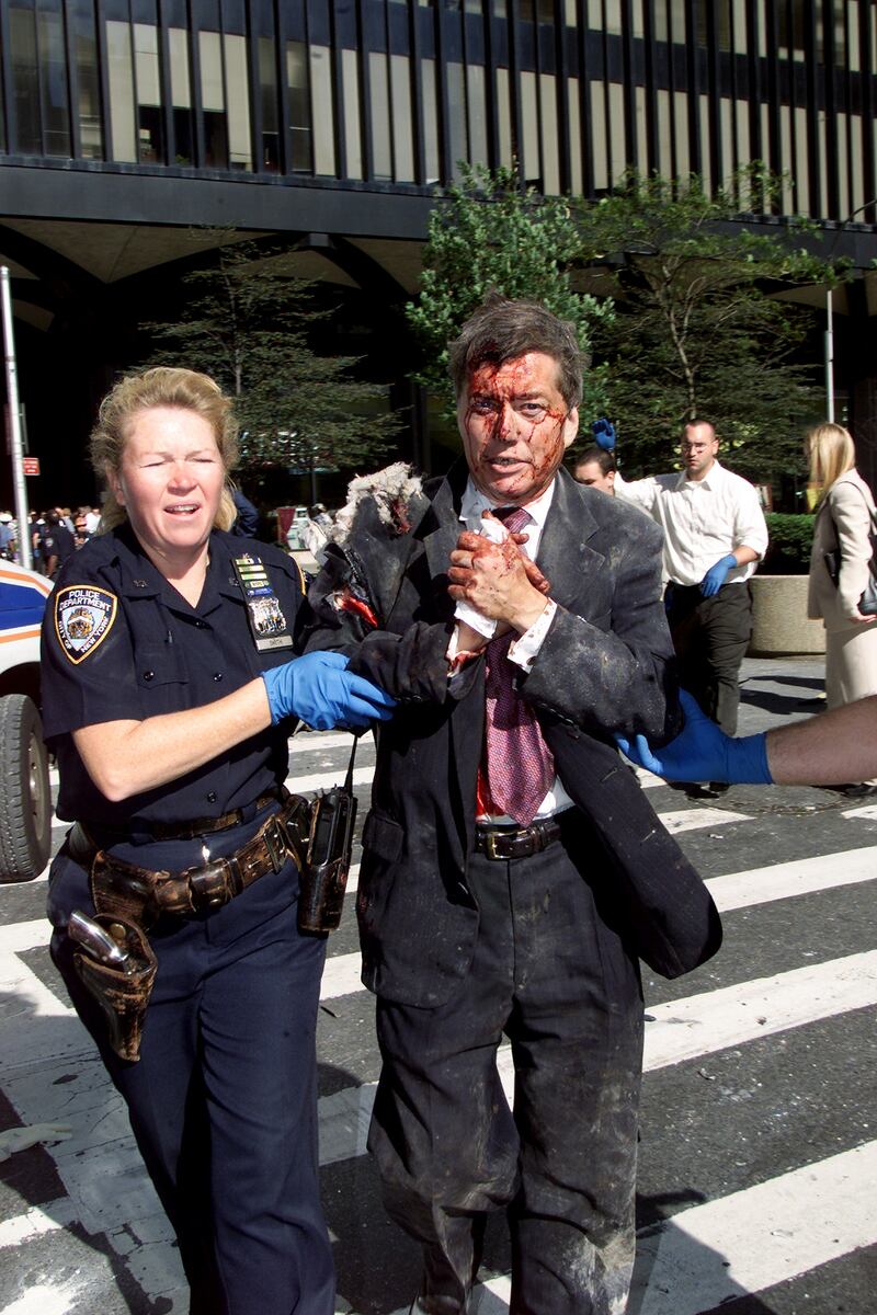 Police Officer Moira Smith helps Edward Nicholls, 50, a broker at Aon, from the south tower of the World Trade Center minutes before its collapse. She reentered the building to assist others in the evacuation and was killed.