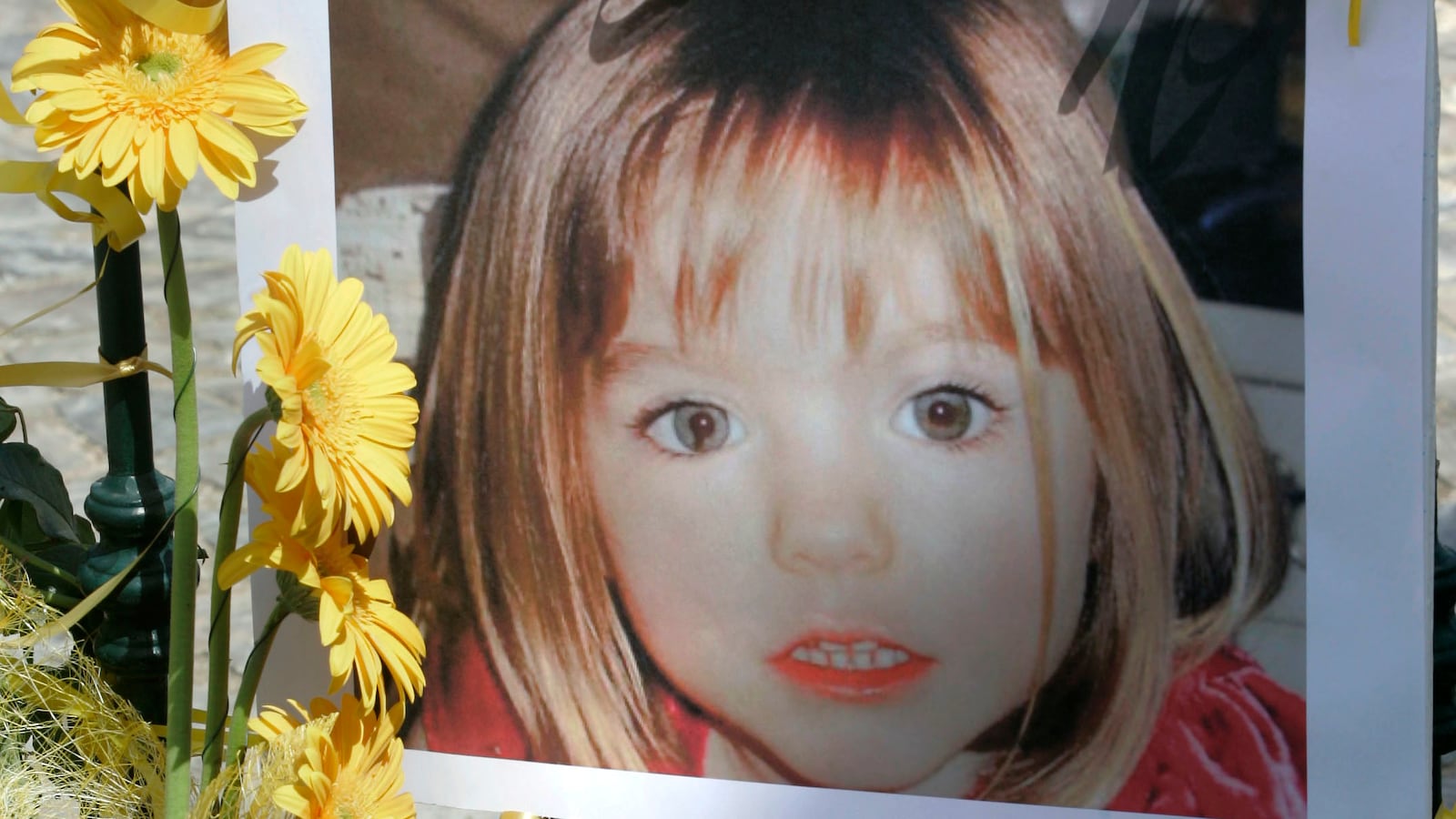 Poster of Madeleine McCann is surrounded by flowers and hope bows in the Portuguese beach resort of Lagos, May 12, 2007.