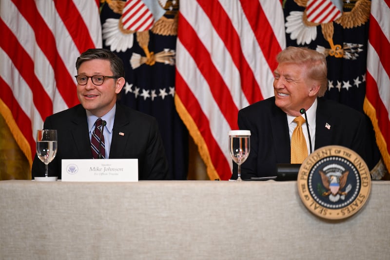 President Donald Trump smiles as House Speaker Mike Johnson speaks about a GOP lawmaker's terminal diagnosis during a lunch with the Kennedy Center Board members at the White House in Washington, DC, on March 16, 2026.