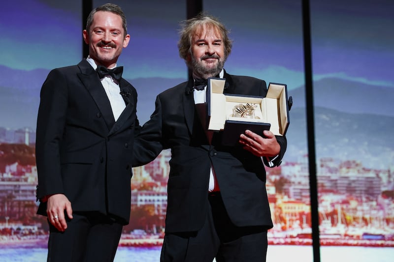 New Zealand filmmaker Peter Jackson poses on stage next to Elijah Wood as he receives an Honorary Palme d'Or Award during the opening ceremony and the screening of the film "La Venus electrique"