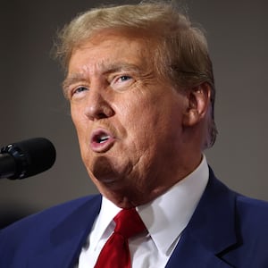 Former President Donald Trump speaks into a microphone.