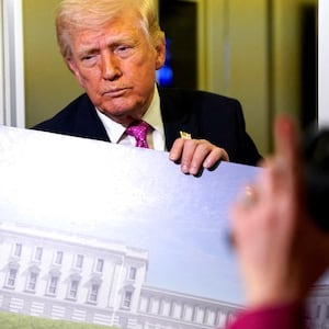 A member of the media raises her hand for a question as U.S. President Donald Trump talks while holding up renderings of the planned White House ballroom, aboard Air Force One en route to Joint Base Andrews, Maryland, U.S., March 29, 2026.