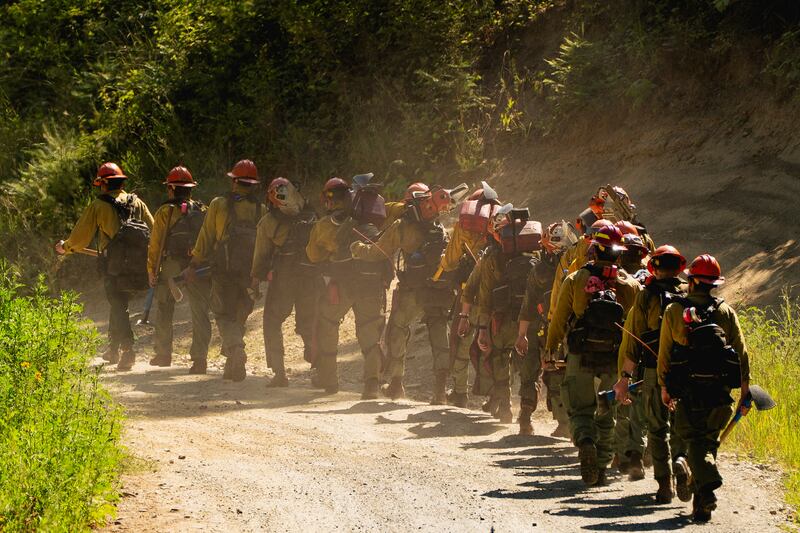 Firefighters enter an area where two firefighters were shot dead while responding to a fire and the body of a man was later found with a gun nearby in the Canfield Mountain area outside Coeur d’Alene, Idaho, U.S. June 30, 2025.  REUTERS/David Ryder