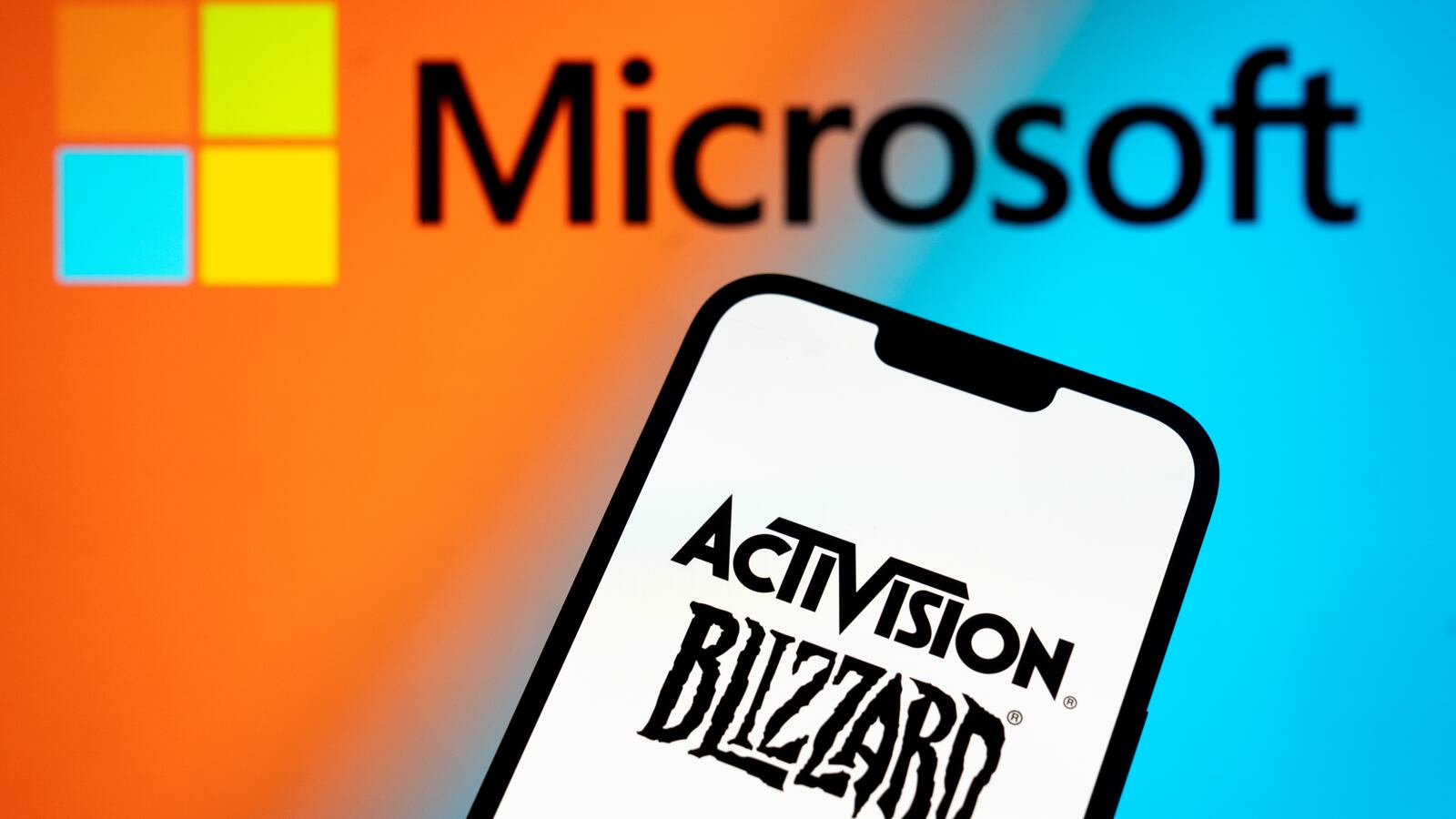 The Activision Blizzard logo is seen with a Microsoft logo in the background in this photo illustration on 13 July, 2023 in Warsaw, Poland.