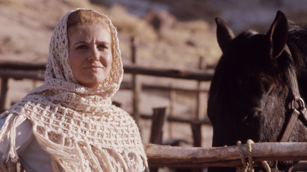 Sharon Acker standing outside next to a horse.