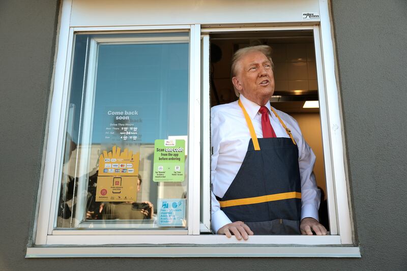Republican presidential nominee, former U.S. President Donald Trump works the drive-through line during a campaign photo op as he visits a McDonald's restaurant on October 20, 2024 in Feasterville-Trevose, Pennsylvania.