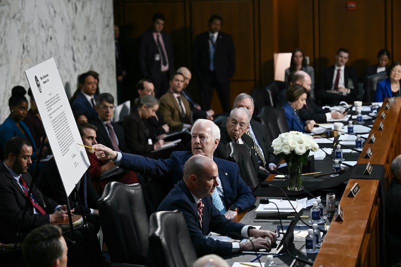 GOP Senator John Cornyn points to a sign displayed behind him during the Senate Judiciary Committee hearing with Acting Attorney General Todd Blanche on July 15, 2026 as he grilled him over the $1.8 billion "Anti-Weaponization Fund."