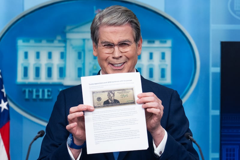 Treasury Secretary Scott Bessent holds a printout of a proposed $250 bill featuring a picture of President Donald Trump