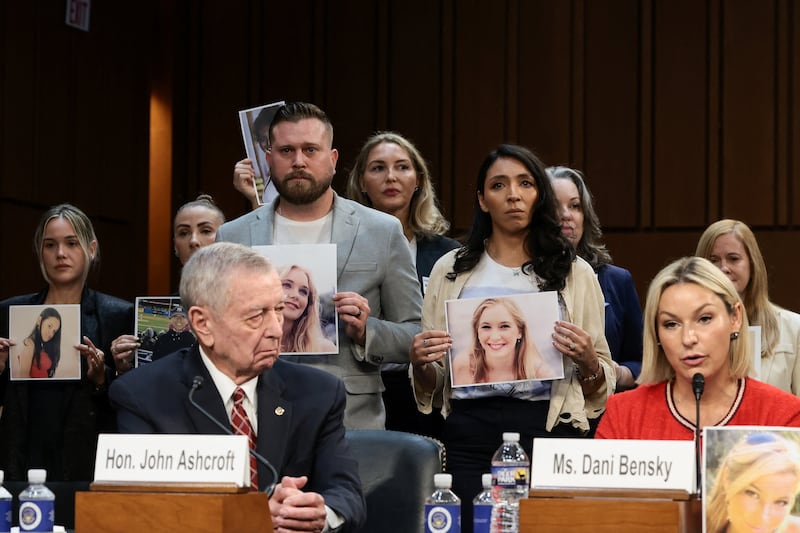 Danielle Bensky, a survivor of Jeffrey Epstein, testifies before the Senate Judiciary Committee as Sky Roberts, the brother of the late victim Virginia Giuffre and Amanda Roberts, her sister-in-law  hold her pictures on Capitol Hill on July 16, 2026.