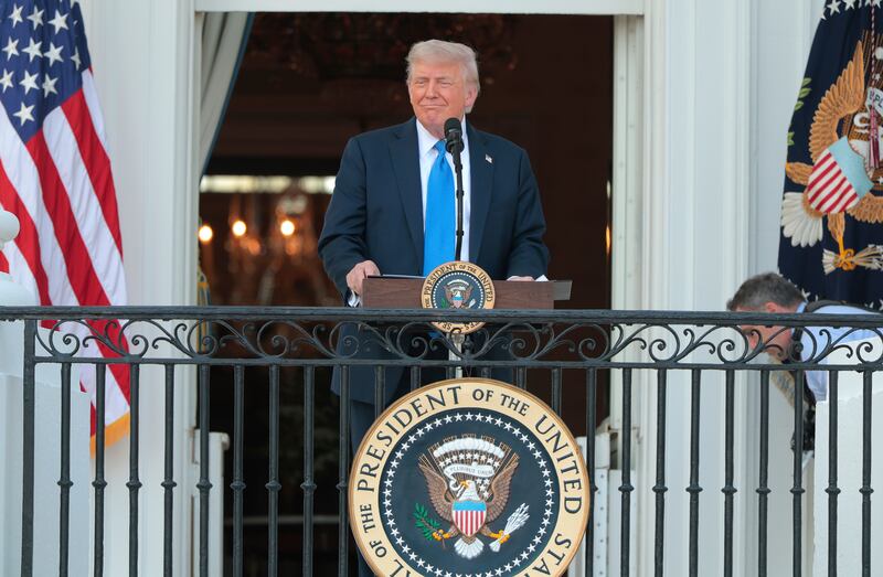 President Donald Trump speaks to guests from the South Portico of the White House during an event on the South Lawn