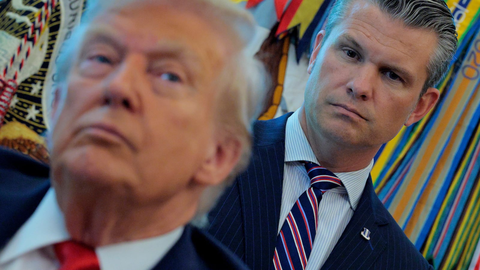 WASHINGTON, DC - AUGUST 25: U.S. Defense Secretary Pete Hegseth listens to President Donald Trump talk to journalists after signing executive orders in the Oval Office at the White House on August 25, 2025 in Washington, DC. Furthering his federal takeover of the capital city’s law enforcement, Trump signed orders ending cashless bail in the District of Columbia, mandating prosecution for people who desecrate the American flag -- including by burning it -- and other orders. (Photo by Chip Somodevilla/Getty Images)