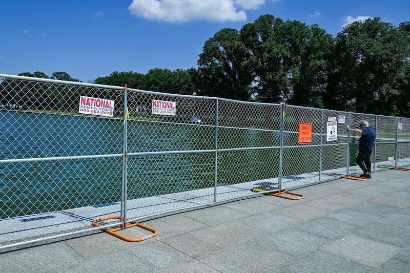 A man looks at the Lincoln Memorial Reflecting Pool as it is blocked off to visitors with fencing
