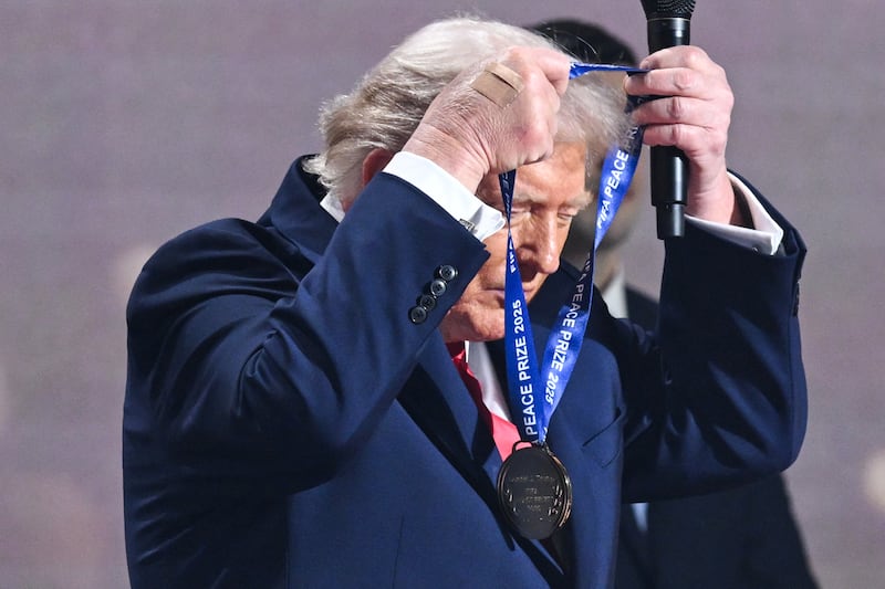 Trump, bandaged hand in full view, received a medal, a trophy, and a certificate.