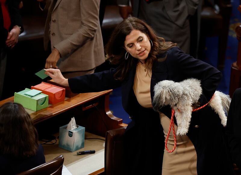 U.S. Rep.-elect Nancy Mace (D-NY) holds a dog as she casts her vote to adjourn in the House Chamber